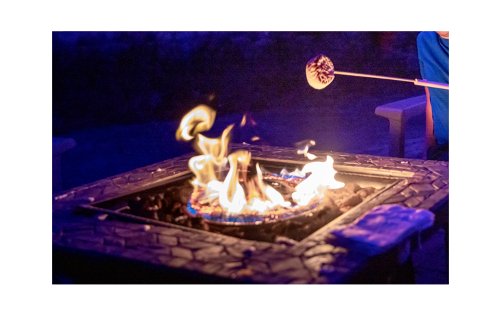a marshmallow on a stick over a fire pit