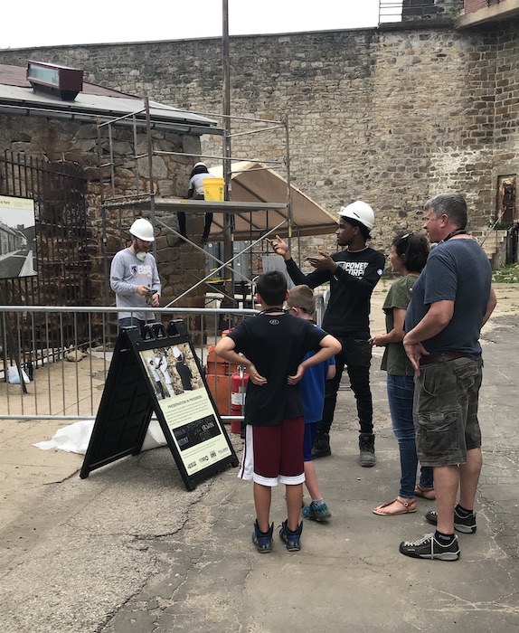 A masonry workshop participant leads a Hands-On History tour.