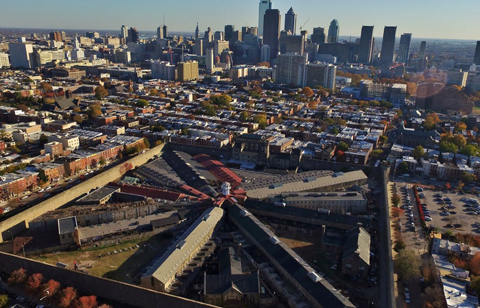 An aerial photograph of Eastern State penitentiary with the Philadelphia skyline in the background.