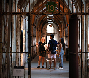 An Eastern State educator leads visitors on a tour of Cellblock 10 during Night Tours Summer Twilight